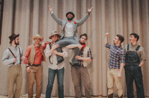 a photo of the cast lifting student Juwan Moore into the air