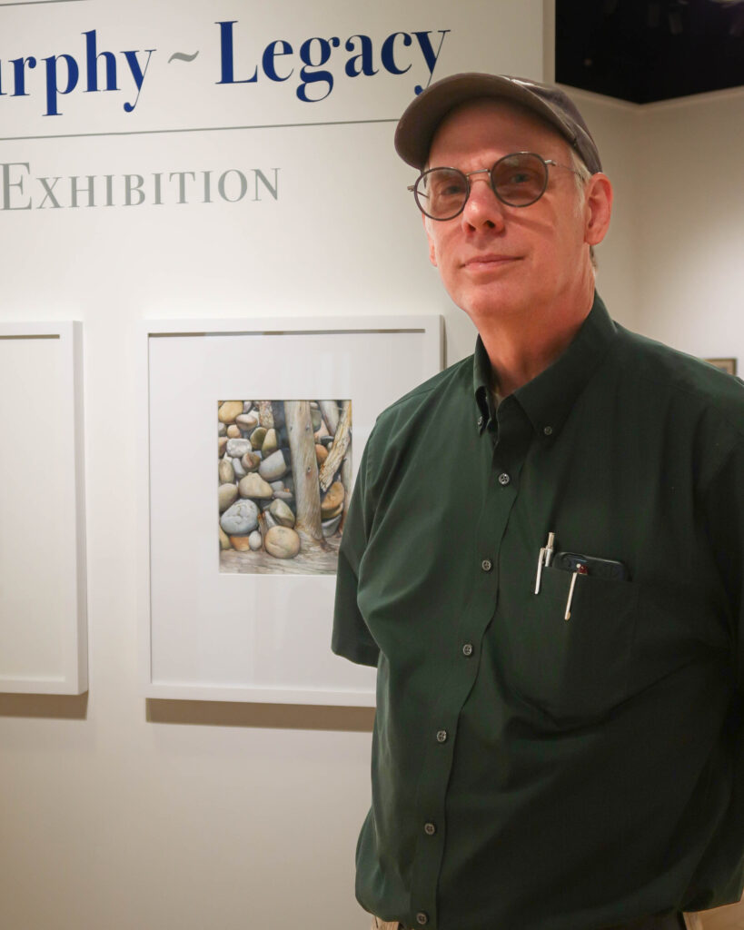 Ted Murphy standing in front of Gallery wall